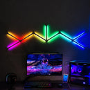 Luminária LED RGB inteligente modular instalada na parede com iluminação colorida em setup gamer com monitor e computador.